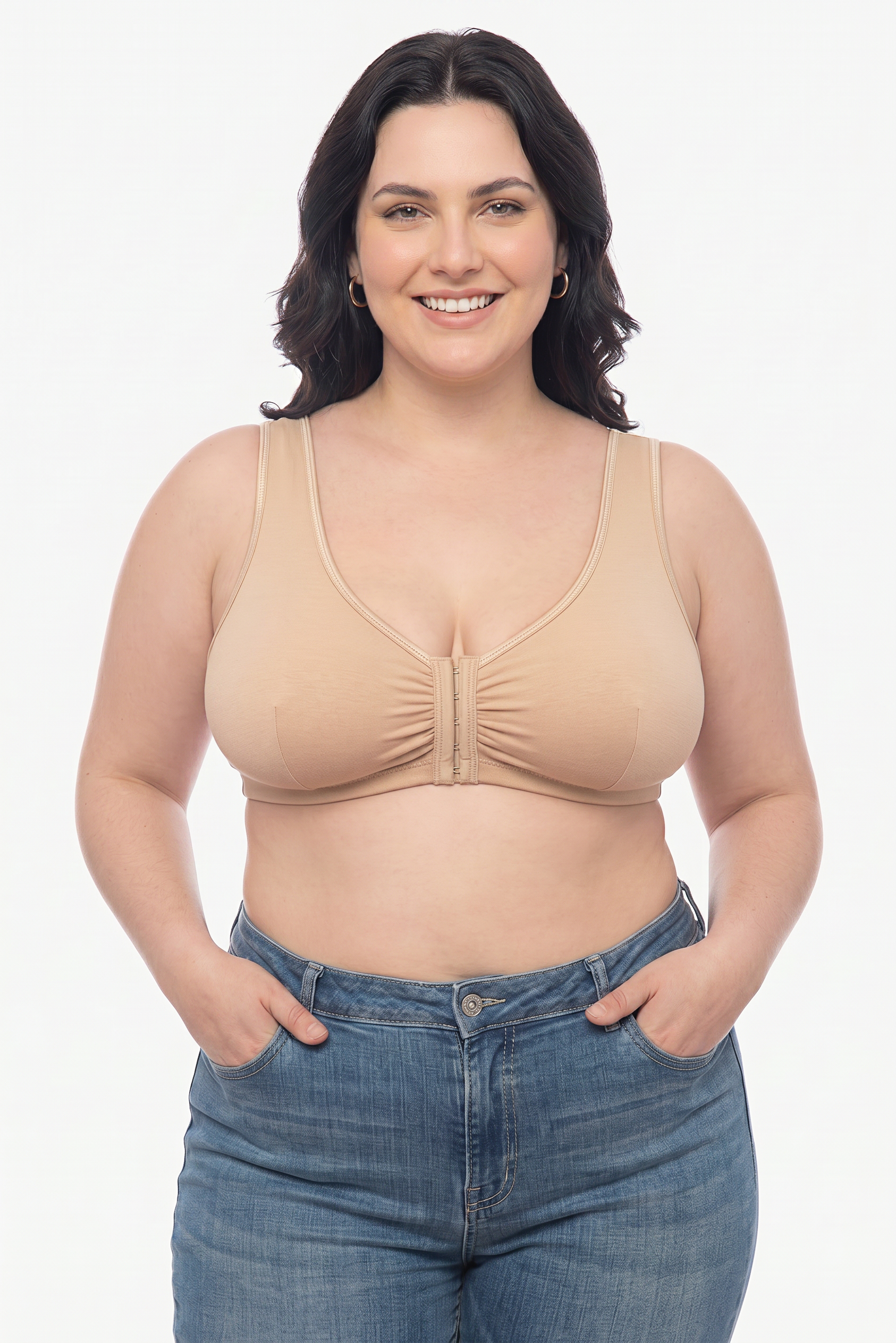 Woman wearing a beige bra and blue jeans on a white background